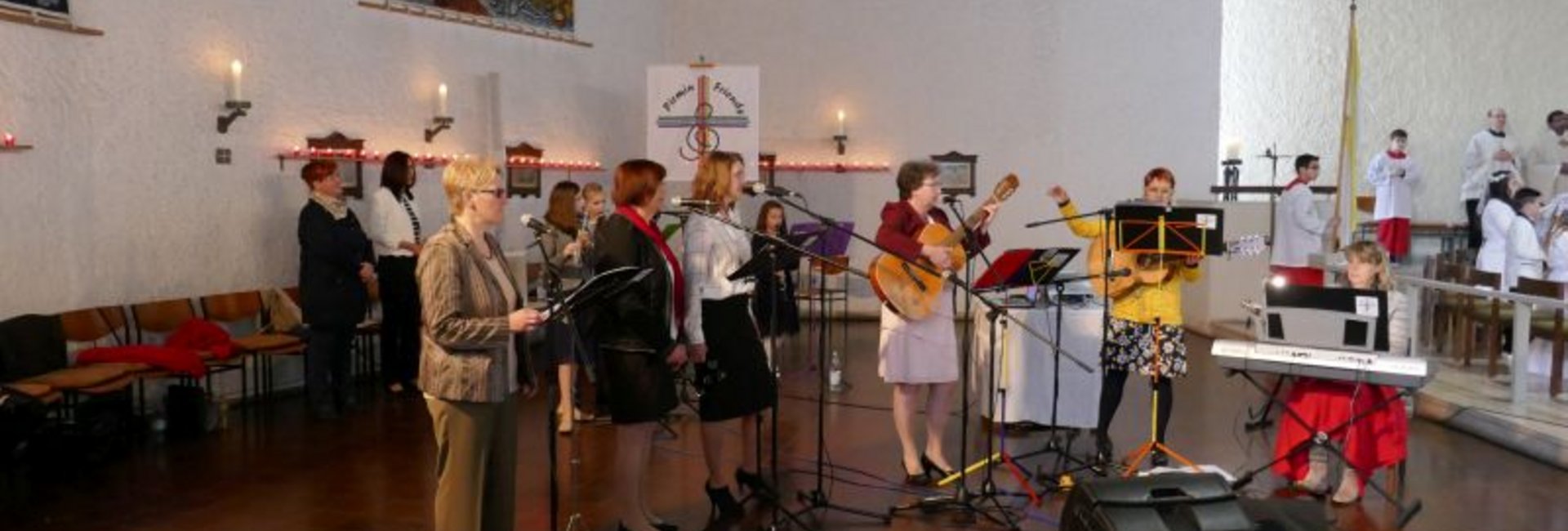 3 Sängerinnen, 2 Gitarrenspielerinnen und eine Frau am Keyboard musizieren neben dem Alatar. 