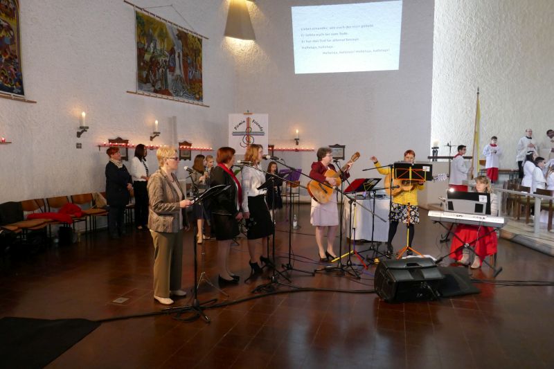 3 Sängerinnen, 2 Gitarrenspielerinnen und eine Frau am Keyboard musizieren neben dem Alatar. 