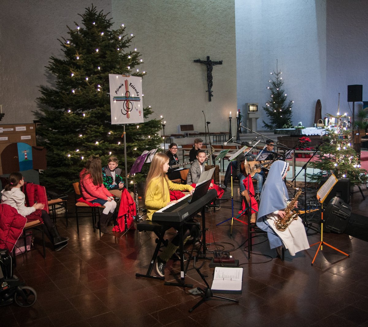 11 Musiker musizieren vor dem Weihnachtsbaum